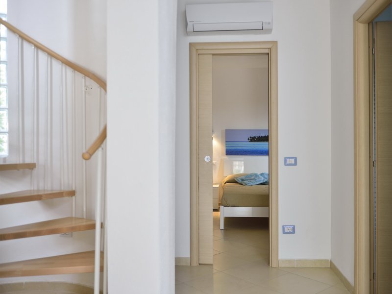 Wendeltreppe ins Obergeschoß, Flur mit Klimaanlage und Blick ins Schlafzimmer 1 Wendeltreppe ins Obergeschoß, Flur mit Klimaanlage und Blick ins Schlafzimmer 1
