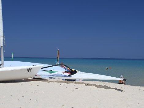 Surfbrett am Strand von Cala Sinzias
