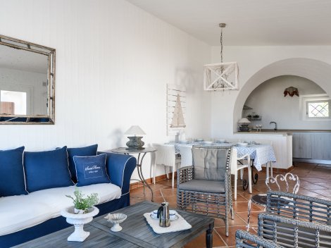 Wohnzimmer mit Sofaecke, Esstisch und Blick durch einen Torbogen in die Küche