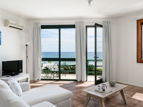 Wohnzimmer mit TV, Klimaanlage und Terrasse zum Meer