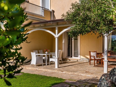 Terrasse davor eine Rasenfläche, Felsen und immergründe Machia