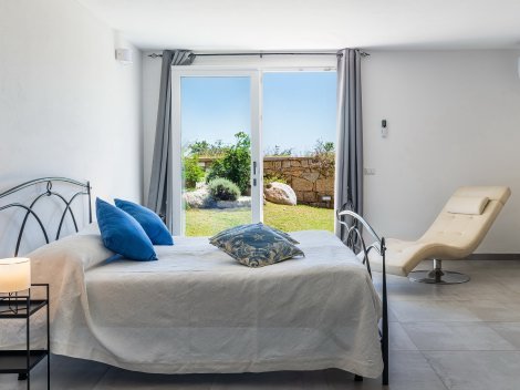 Masterbedroom mit Doppelbett und Zugang zum Garten