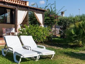 Garten mit bequemen Liegestühlen zum Entspannen in der Sonne